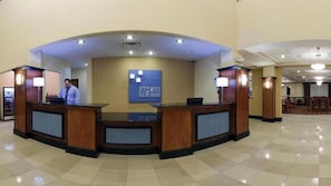 A hotel reception area with a reception desk, a blue sign with the hotel name, and a spacious lobby with a tiled floor. - Holiday Inn Express Hotel & Suites Bainbridge by IHG (Bainbridge)