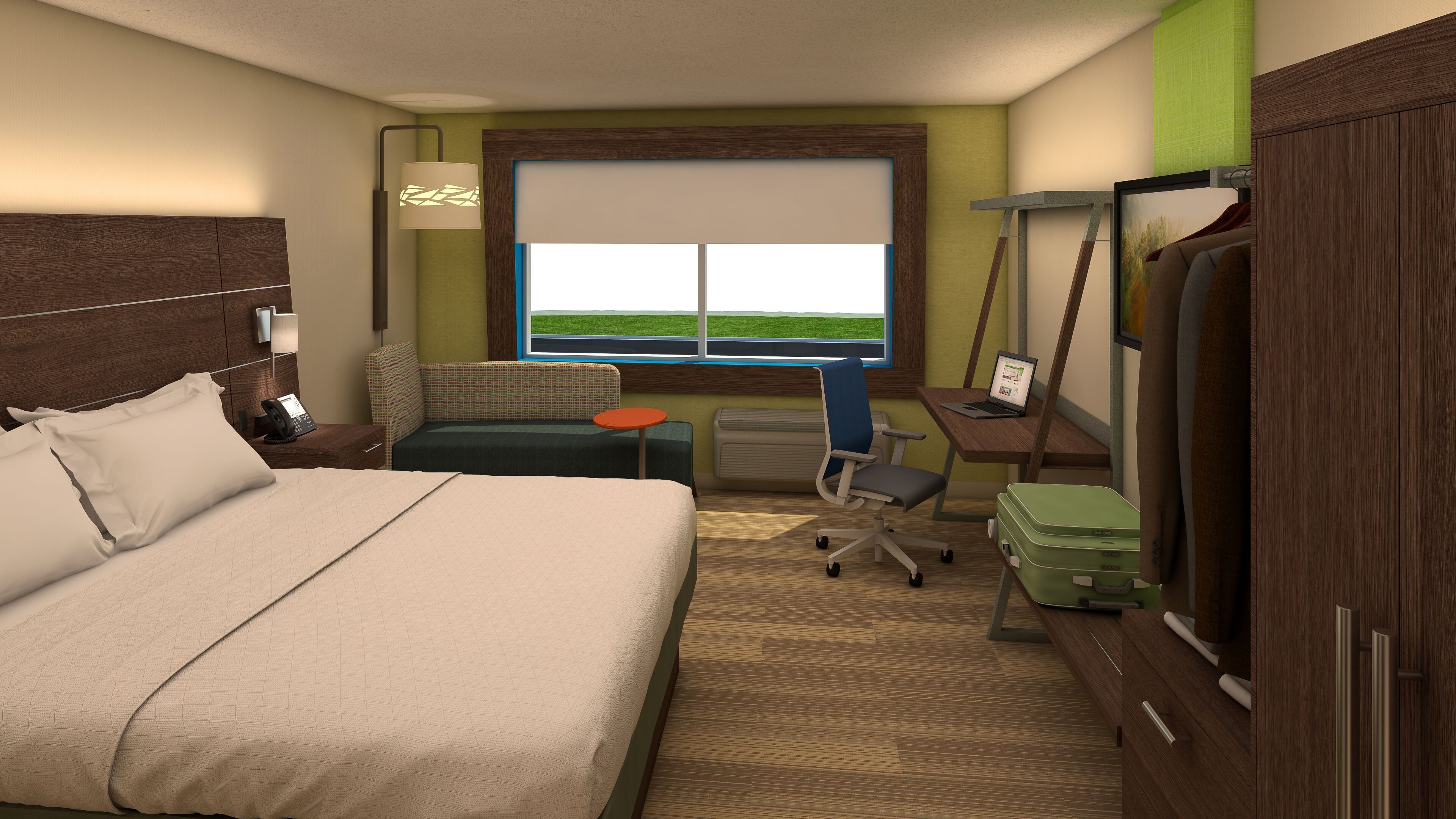 Habitación de hotel con cama, escritorio, silla, maleta y ventana con vistas.