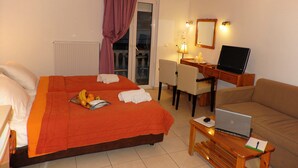 A hotel room with a bed, desk, laptop, and a sofa. - Hotel Aria (Samos)