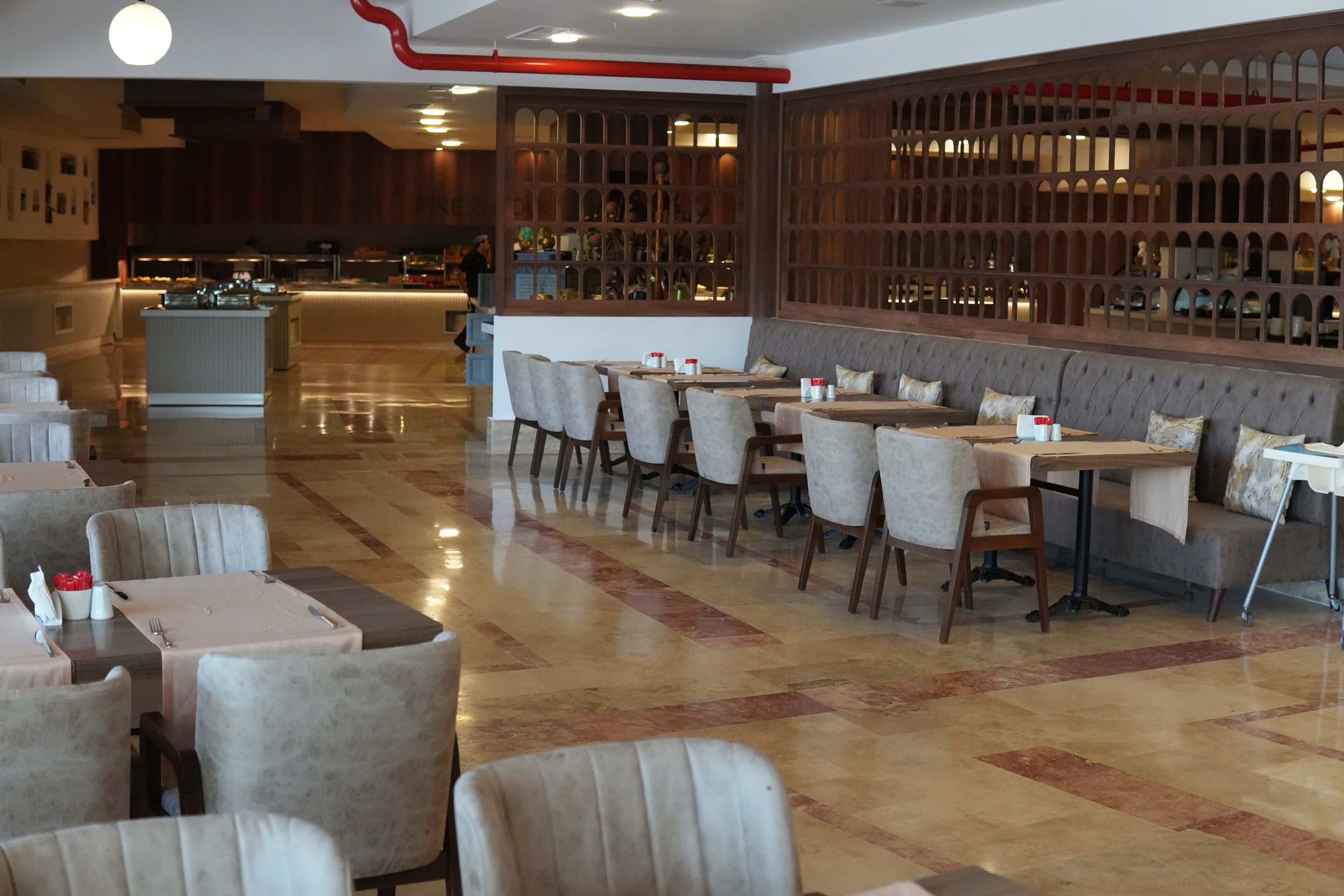 A restaurant with a bar area, seating arrangements, and a polished floor.