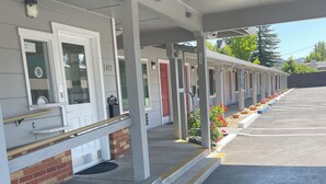 Un motel con estacionamiento techado, habitaciones separadas con acceso directo y cimientos de ladrillo.