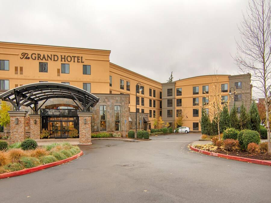Entrada de un hotel con un camino cubierto y un letrero que dice "The Grand Hotel".
