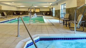 Un espace spa comprenant un jacuzzi, des chaises longues et une piscine séparée.
