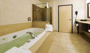Un bagno con una vasca da bagno ampia, una doccia e un lavandino.