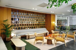 Un espacio lounge moderno con una pared de madera, asientos y un ventanal grande.