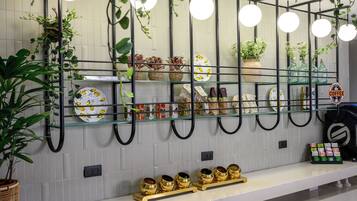 A modern kitchen with a glass shelf displaying kitchenware and a coffee station.
