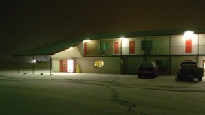 A gas station at night with two cars parked in front. - Narrow Gauge Railroad Inn (Antonito)