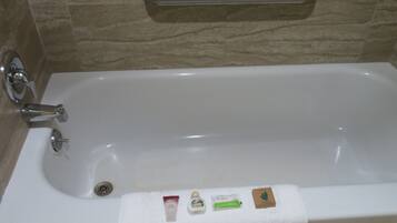 Une salle de bain équipée d’une baignoire, d’une barre d’appui et d’un porte-serviettes.
