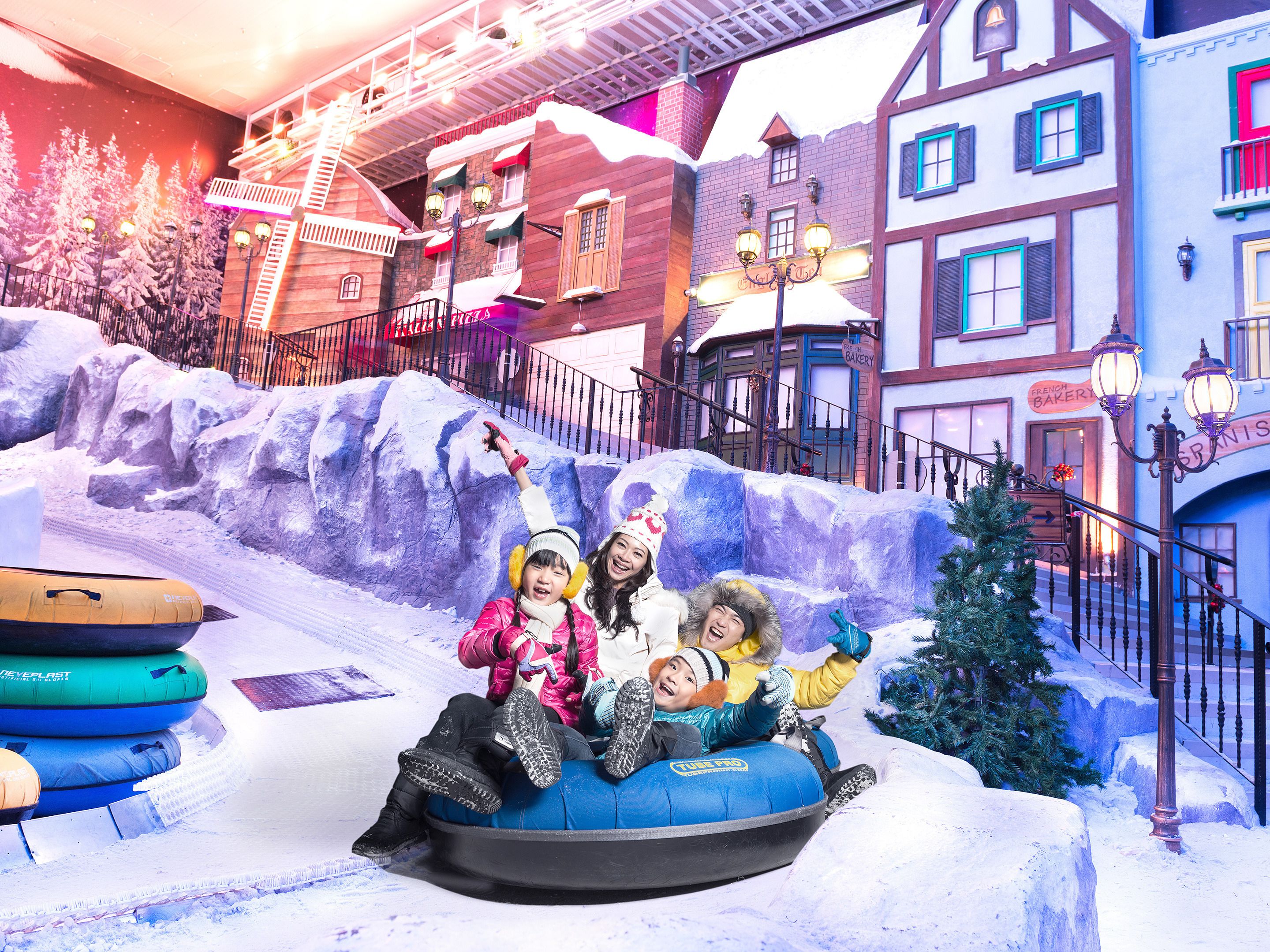 A snow-covered street with buildings and a snowball fight area.