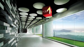 A modern corridor with a glass wall and a view of a green landscape. - Resorts World Genting - First World Hotel (Genting Highlands)