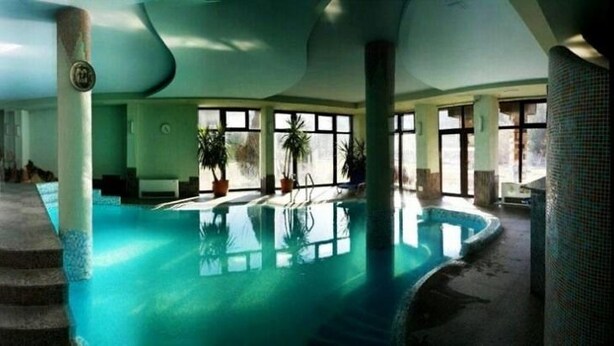 An indoor swimming pool with a unique design, including a spiral staircase leading to the pool area. - Hotel Orphey Bansko (Bansko)