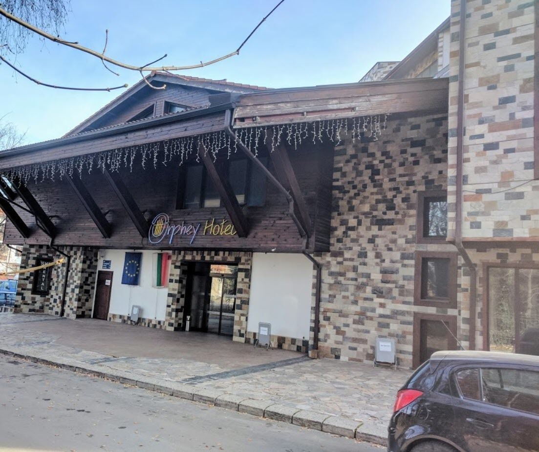 A hotel with a tiled facade, a sign reading "Orygyn Hotel," and a visible entrance.