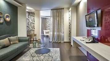 A modern living room with a sofa, coffee table, and a TV mounted on the wall.