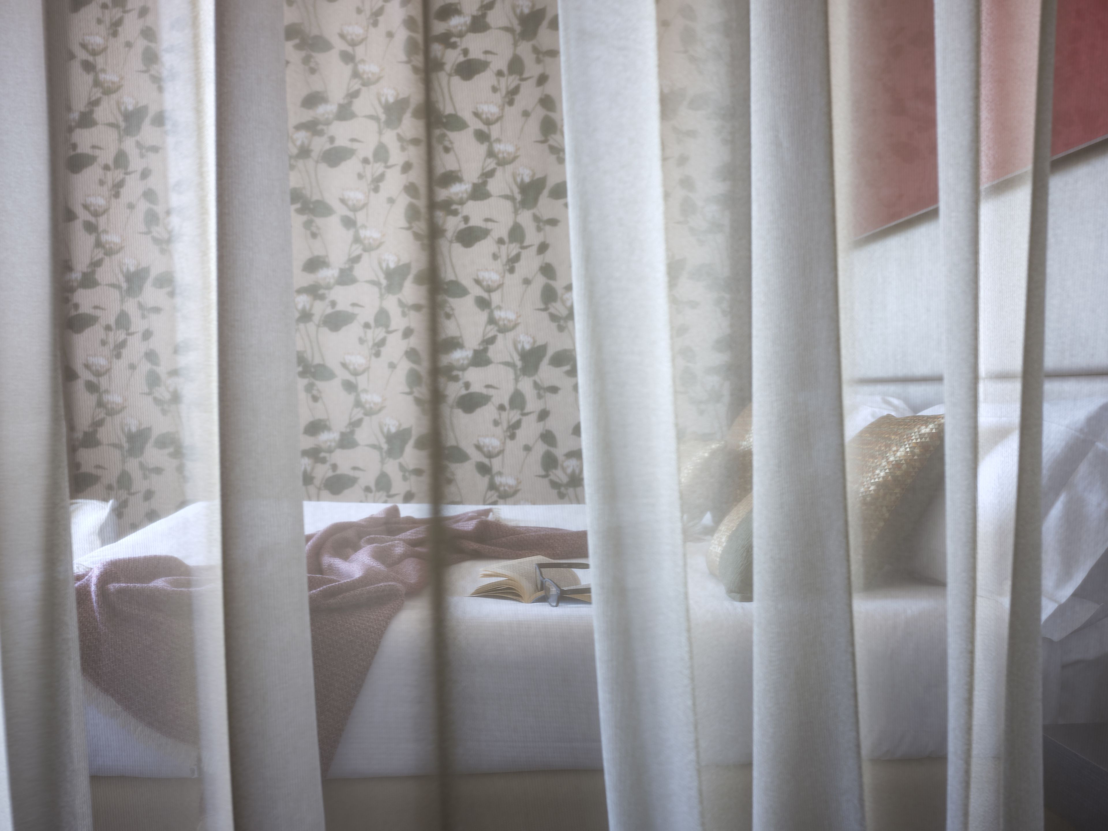 A bedroom with a bed, pillows, and a blanket.