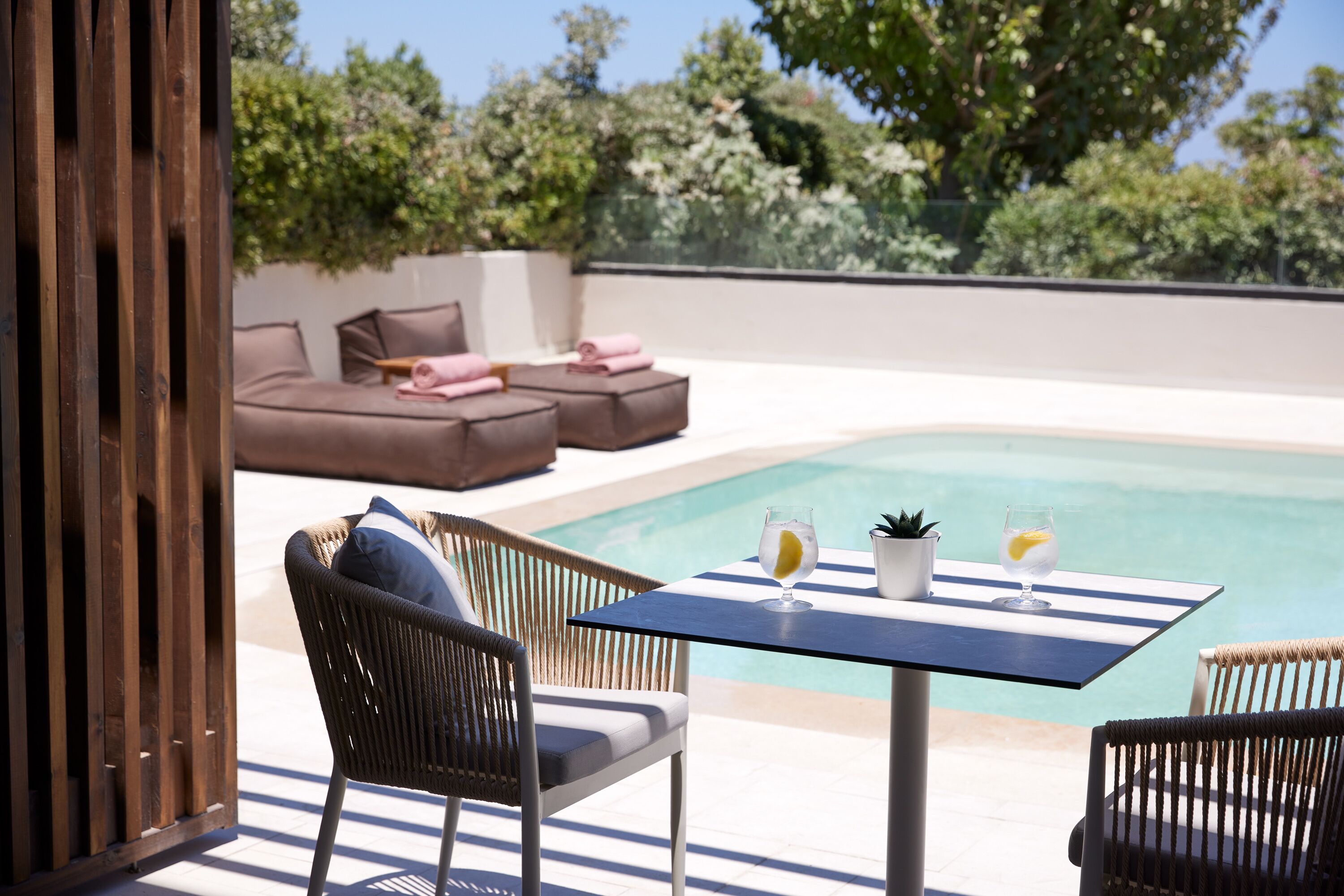 Ein Poolbereich mit Tisch, Stühlen und einer Couch.