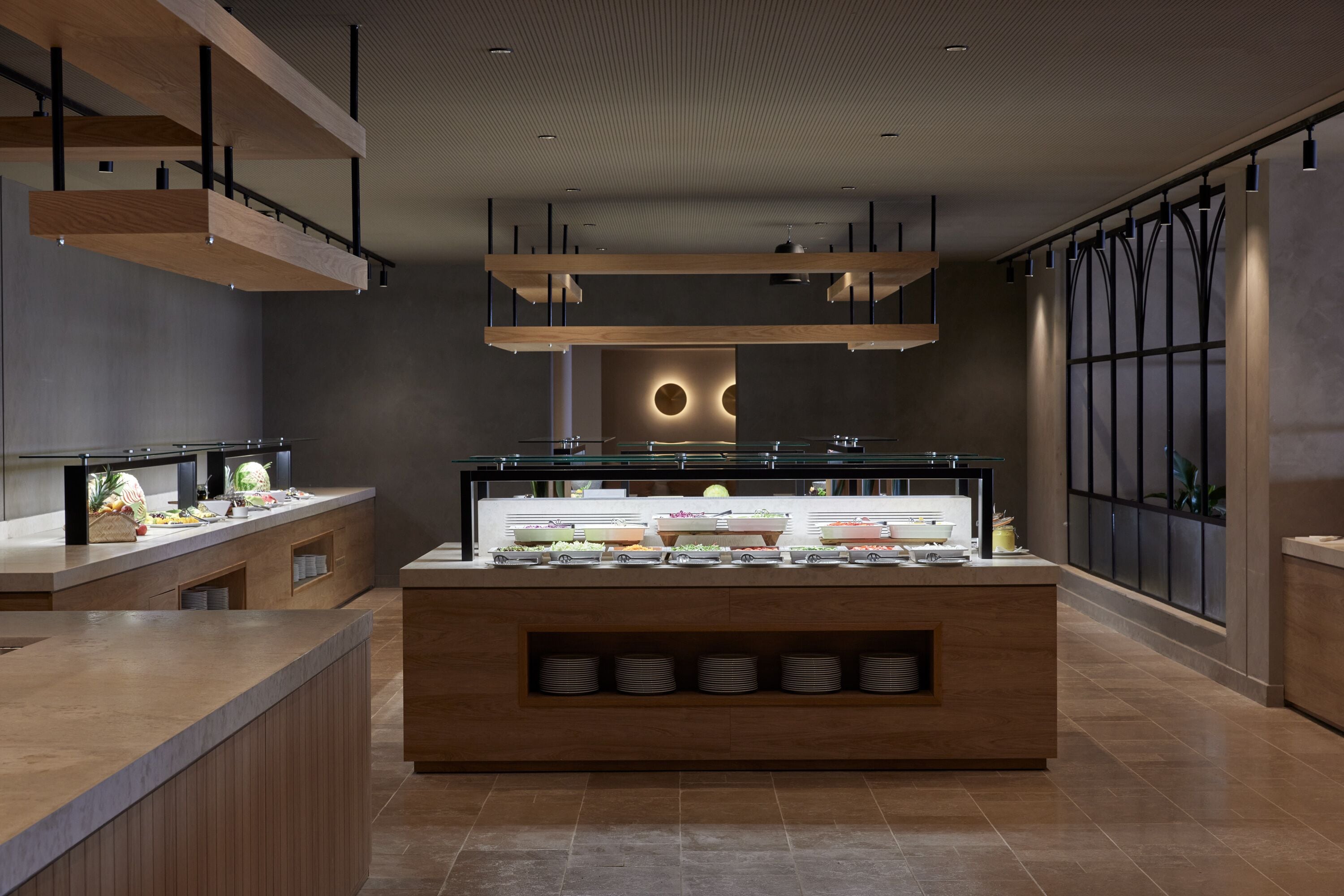 A modern kitchen with a central island, wooden beams, and a glass display case.