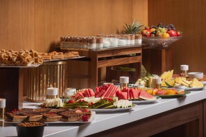 A buffet with various desserts, fruits, and beverages. - NH Lyon Airport (Colombier-Saugnieu)