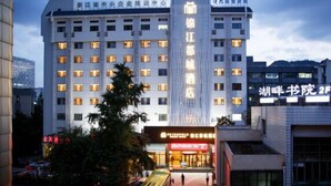 A multi-story hotel with illuminated signage, a central vertical sign, and a ground-level entrance with a storefront. - Jinjiang Metropolo Hotel (Hangzhou Huanglong Sports Center Wensan Road Subway Station Branch) (Hangzhou)