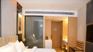 A hotel room with a large bed, a desk, a chair, a mirror, and a wardrobe. - Jinjiang Metropolo Hotel (Hangzhou Huanglong Sports Center Wensan Road Subway Station Branch) (Hangzhou)