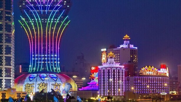 A brightly lit building with a distinctive curved top and a large illuminated sign reading "Grand Lisboa." - Grand Lisboa Macau (Macau)