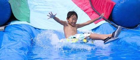 A person in a blue inflatable water slide.