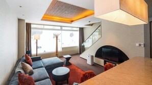 A modern living room with a sofa, coffee table, and fireplace. - Naeba Prince Hotel (Yuzawa)