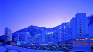 A hotel with multiple buildings, a parking lot, and mountains in the background. - Naeba Prince Hotel (Yuzawa)