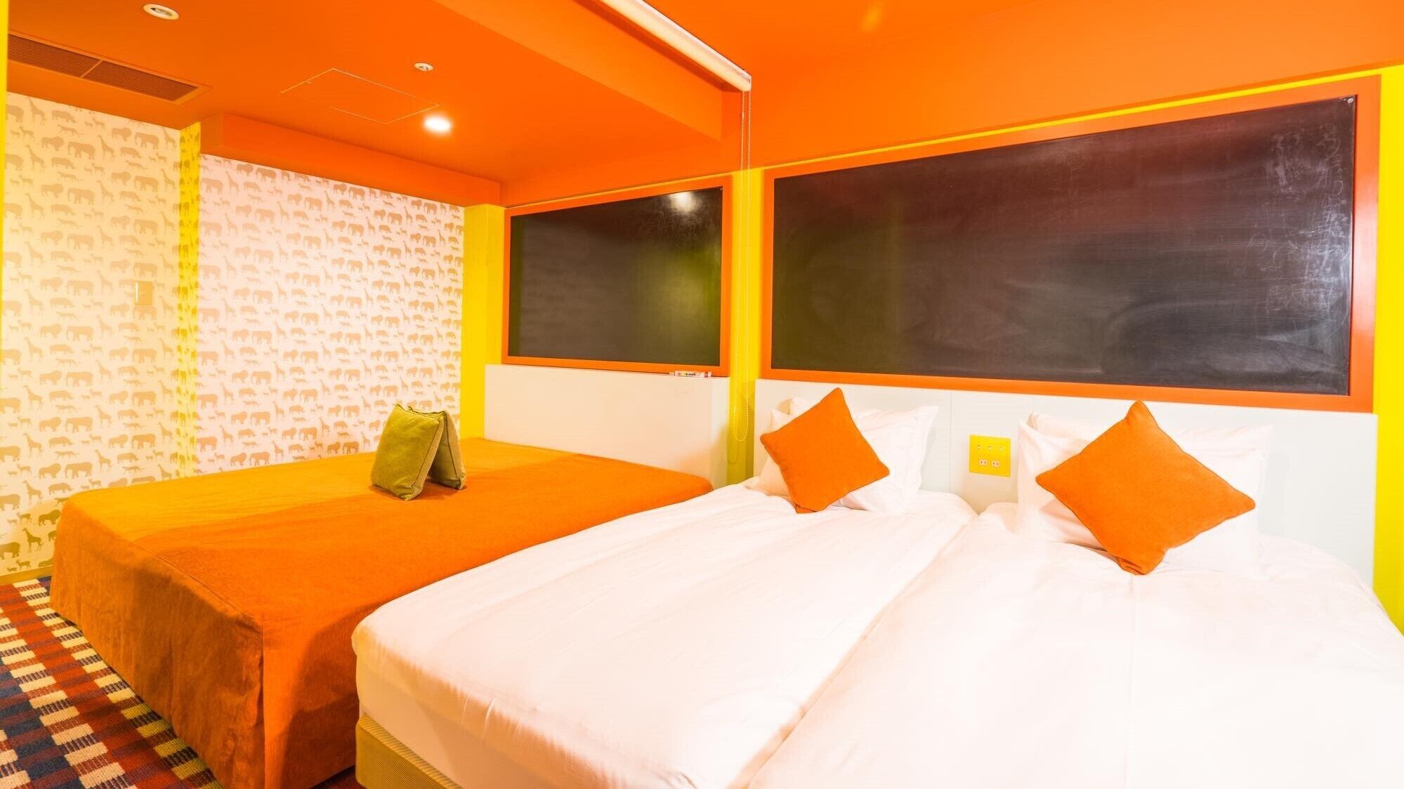 A hotel room with two beds, a patterned wallpaper, and a check-in station.