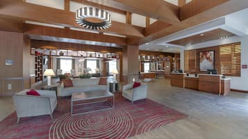 A spacious lobby with a reception desk, seating area, and a patterned rug.
