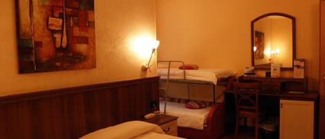 A hotel room with two beds, a desk with a chair, a small cabinet, a mirror, and a painting on the wall.