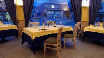 Un restaurante con mesas dispuestas para comer, sillas y vistas a la calle.