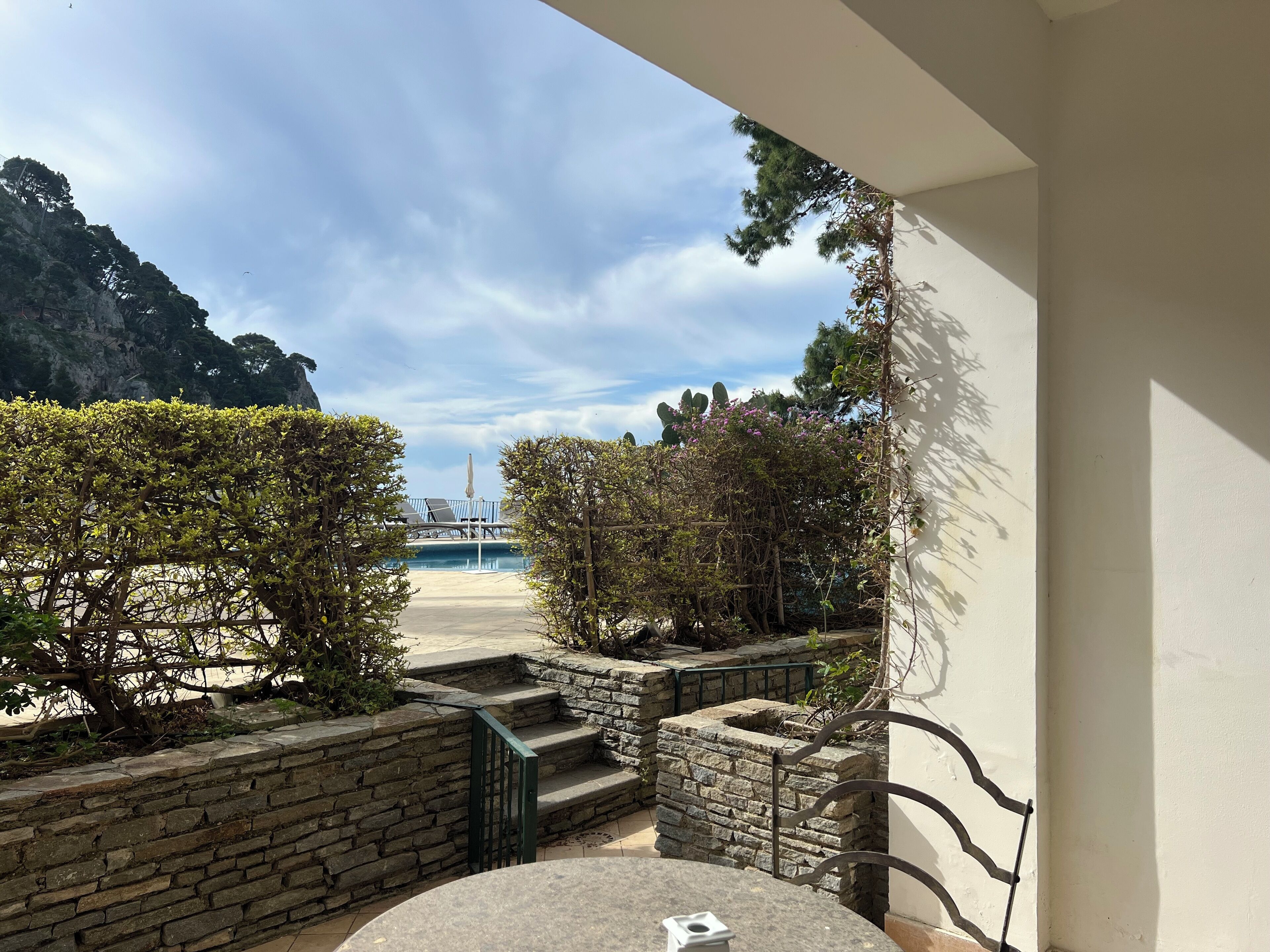 A balcony with a view of a pool and mountains.