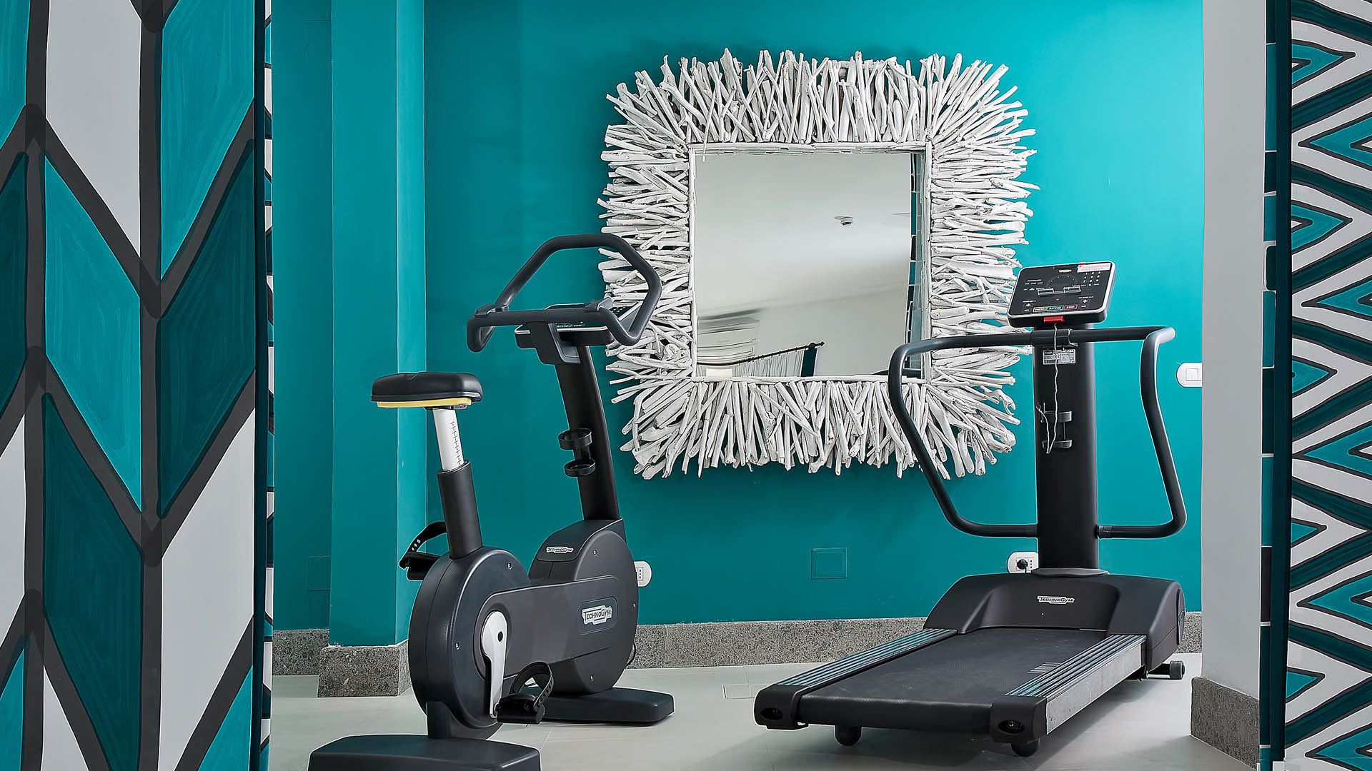 A fitness room with two stationary bikes and a treadmill.