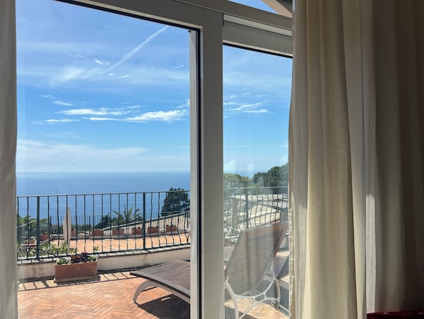 A balcony with a view of the sea, potted plants, and a chair. - Hotel della Piccola Marina (Capri)