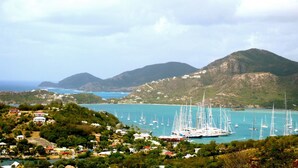 A coastal town with a marina filled with sailboats, surrounded by hills and a clear view of the sea. - HBK Villa Rentals at Jolly Harbour (Jolly Harbour)