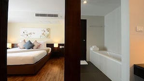 A modern hotel room with a large bed, a bedside table, a nightstand, and a wall-mounted artwork. - Serene at Chiang Rai (Chiang Saen)
