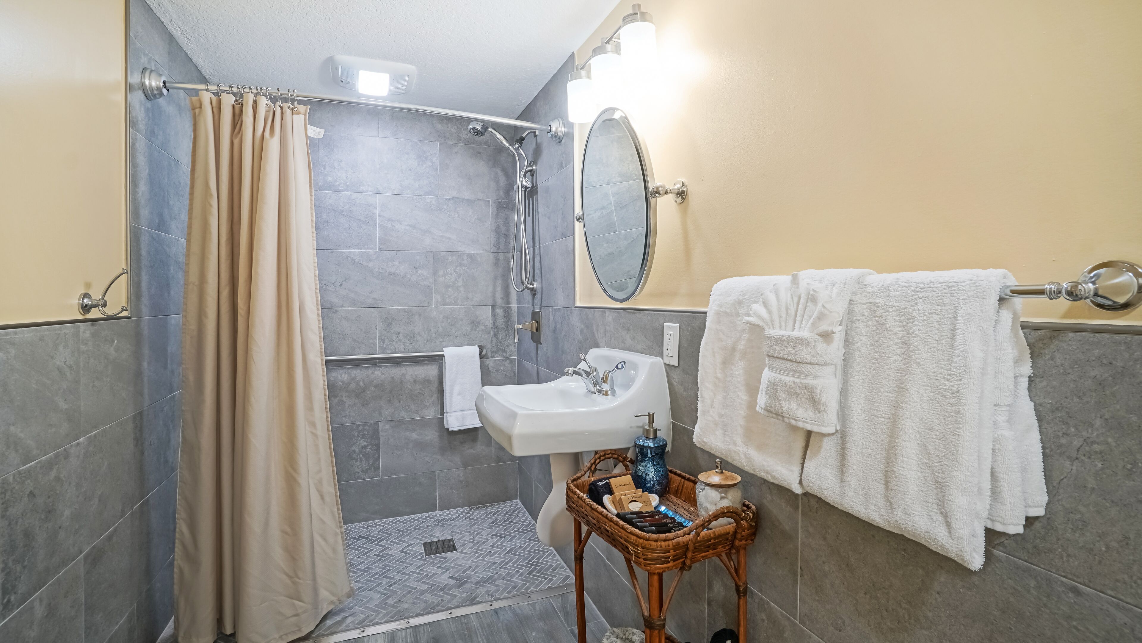 Un baño con ducha, lavabo y espejo.
