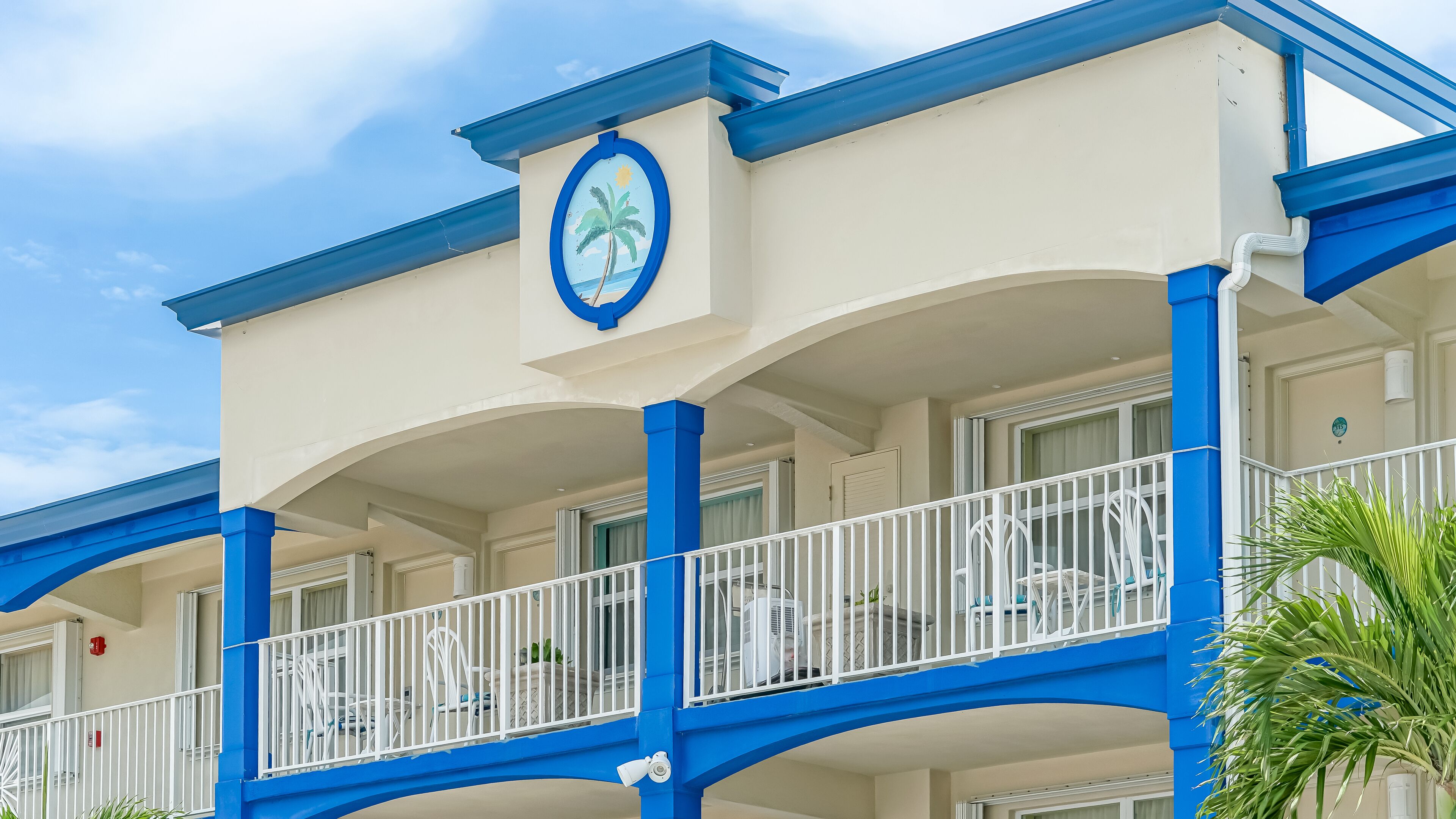 Un hotel con balcón, barandillas blancas y una decoración en tonos azul y blanco.