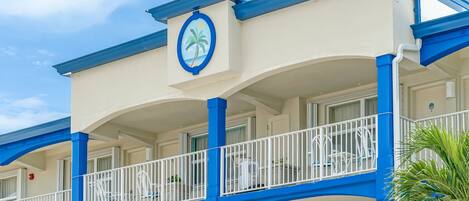 Un hotel con balcón, barandillas blancas y una decoración en tonos azul y blanco.