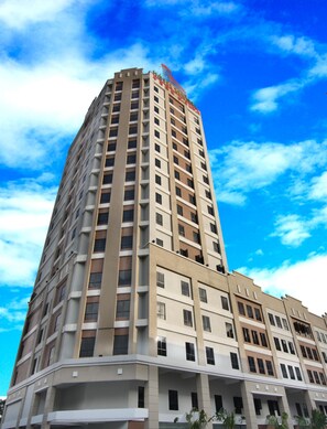 Un hôtel à plusieurs étages au design moderne, avec un logo bien visible sur sa façade.