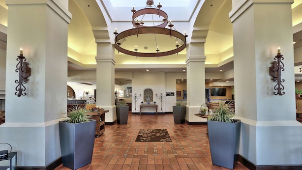 A spacious lobby with a high ceiling, a central chandelier, and large windows allowing natural light. - Hilton Garden Inn Las Cruces (Las Cruces)