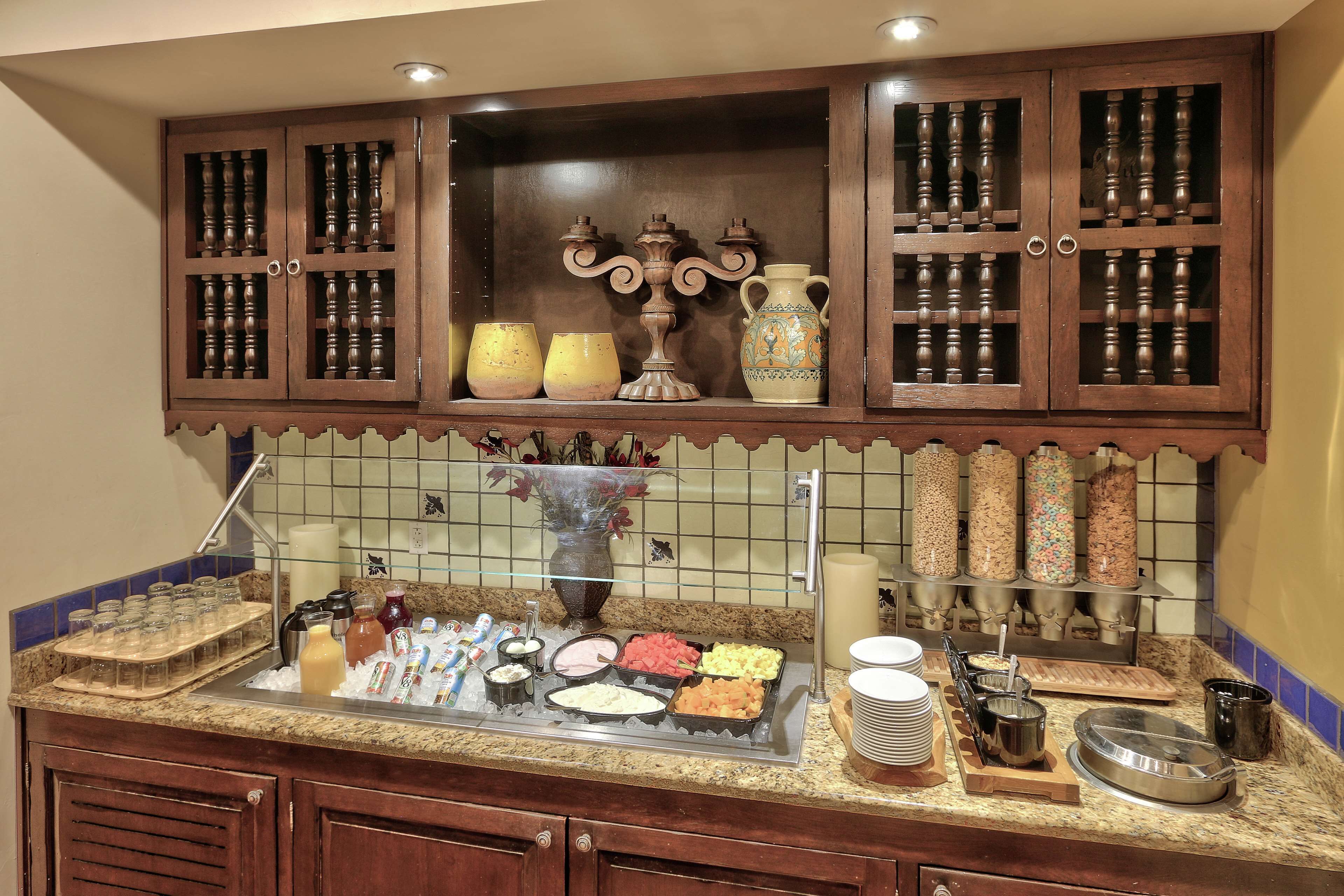 A buffet setup with various food items, a glass display case, and a decorative vase.