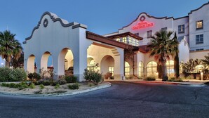A hotel with a distinctive arched entrance and a clear sign reading "Hilton Garden Inn." - Hilton Garden Inn Las Cruces (Las Cruces)