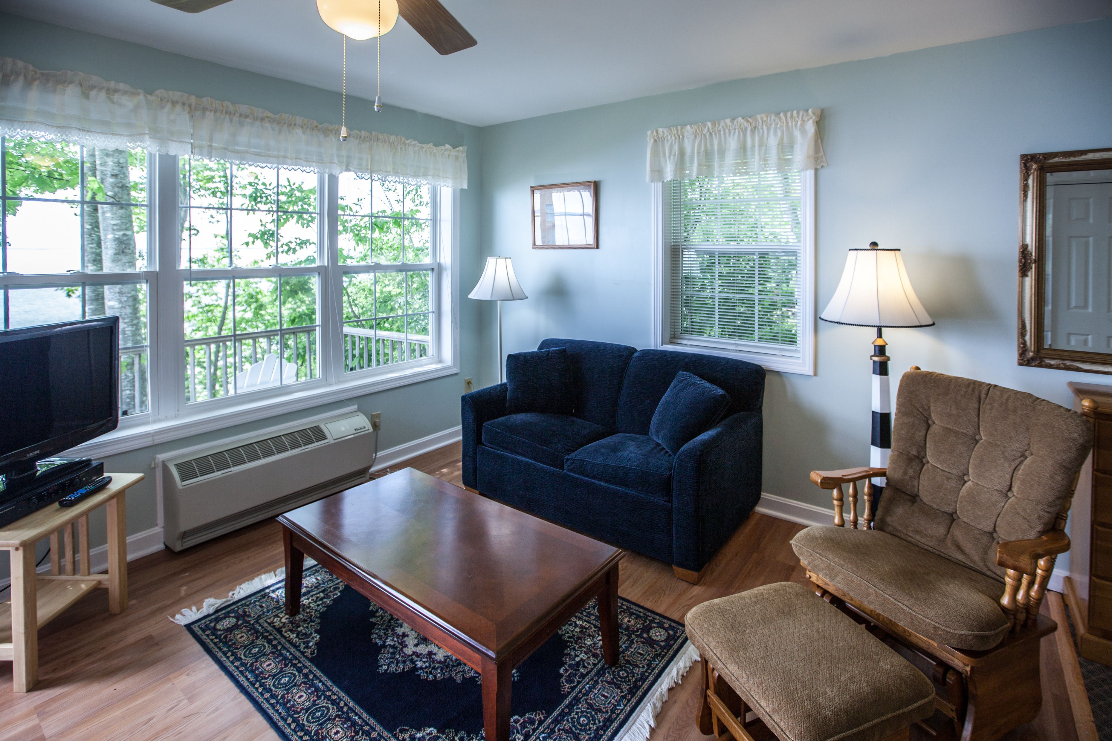 A living room with a television, sofa, armchair, and coffee table.
