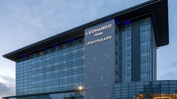 Un edifici modern d'hotel amb un senyal ben visible per 'Leonardo Hotels Unionsquare'.