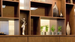 A modern living room with two sofas, a coffee table, and a shelving unit with decorative items.