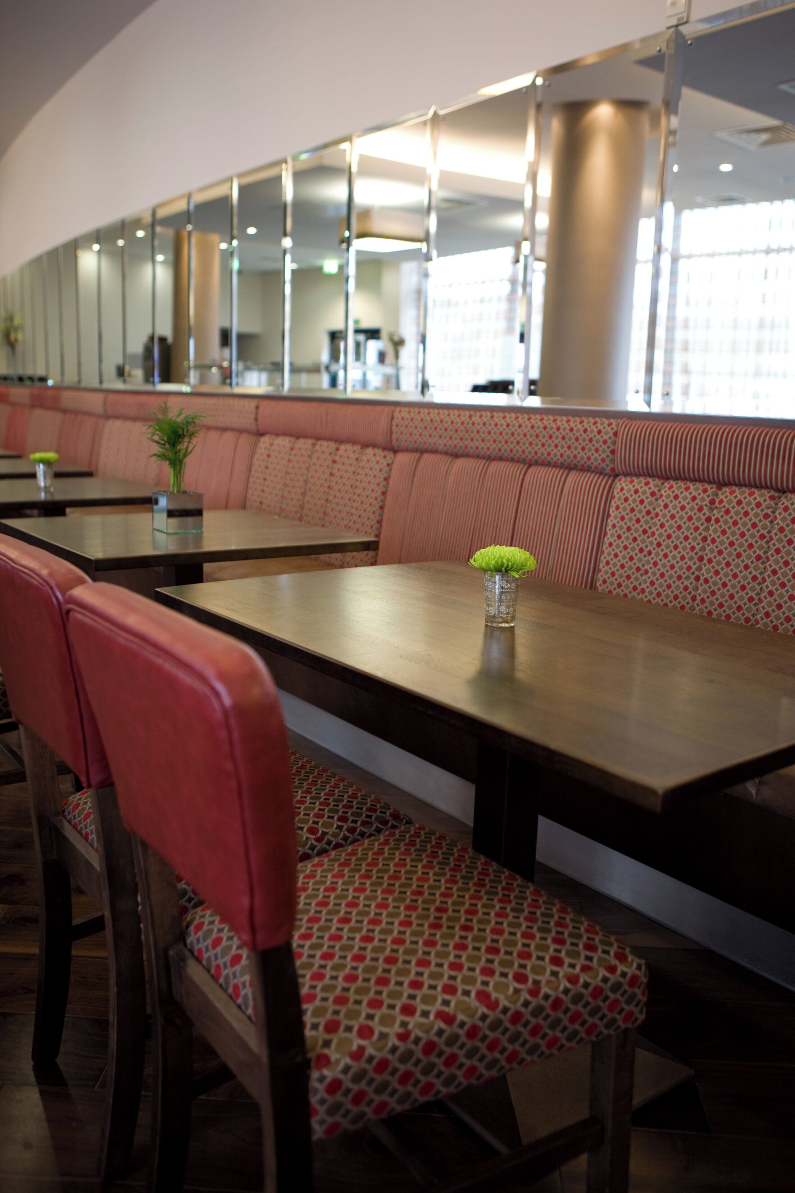 A restaurant with booths, wooden tables, and cushioned seating.