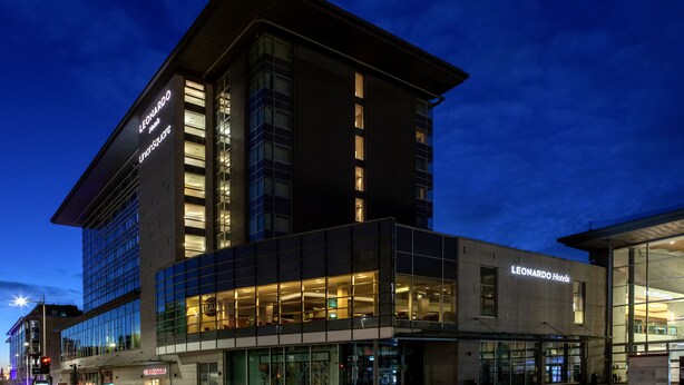 A modern hotel with a prominent 'Leonardo Hotels' sign, large glass windows, and a structured facade.