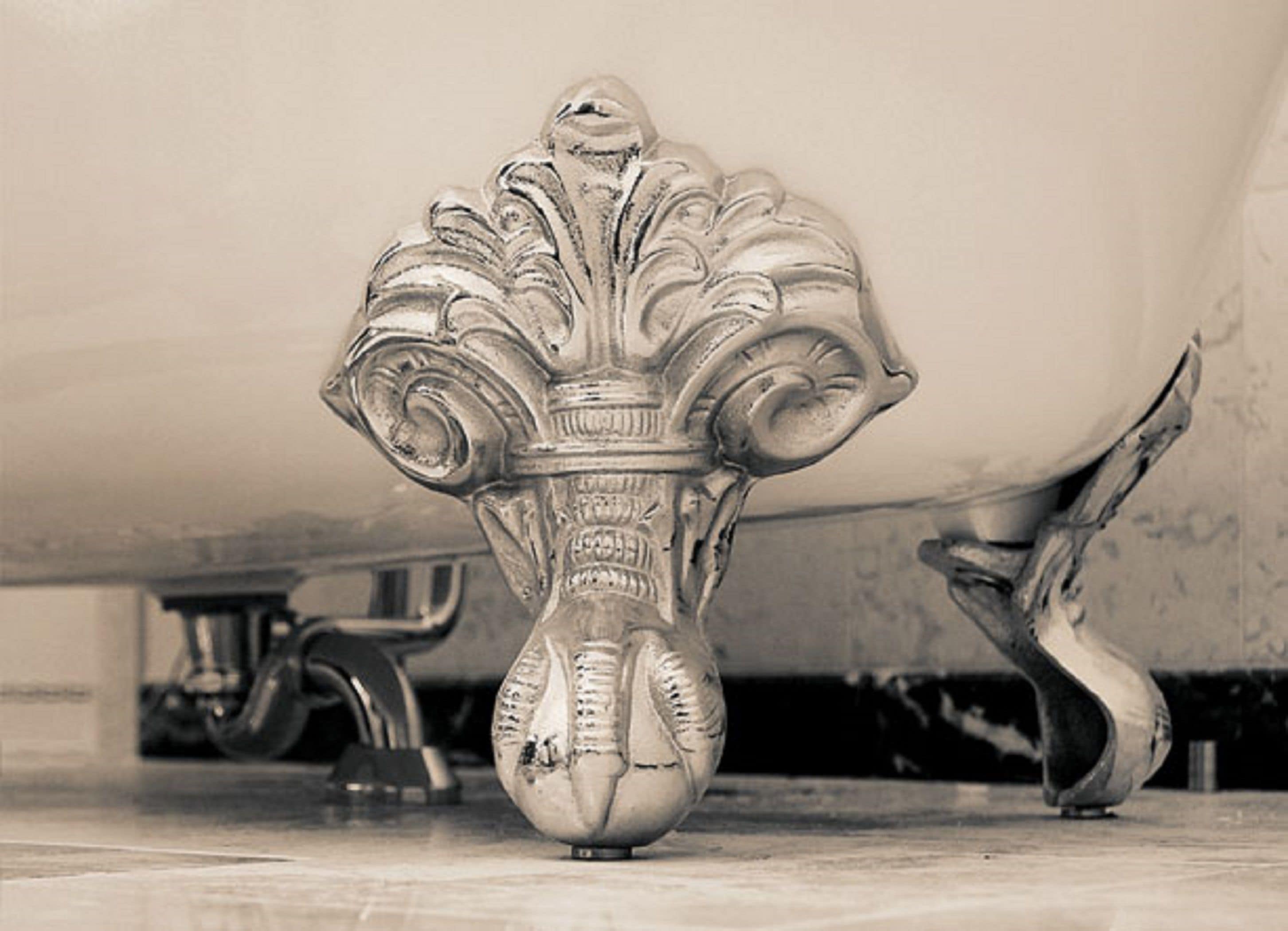 Un jarrón metálico antiguo y ornamentado con diseños intrincados, sobre un suelo de baldosas bajo una gran construcción.
