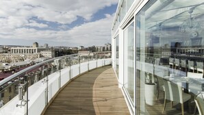 Un edificio moderno con un balcón curvo que da a un paisaje urbano.